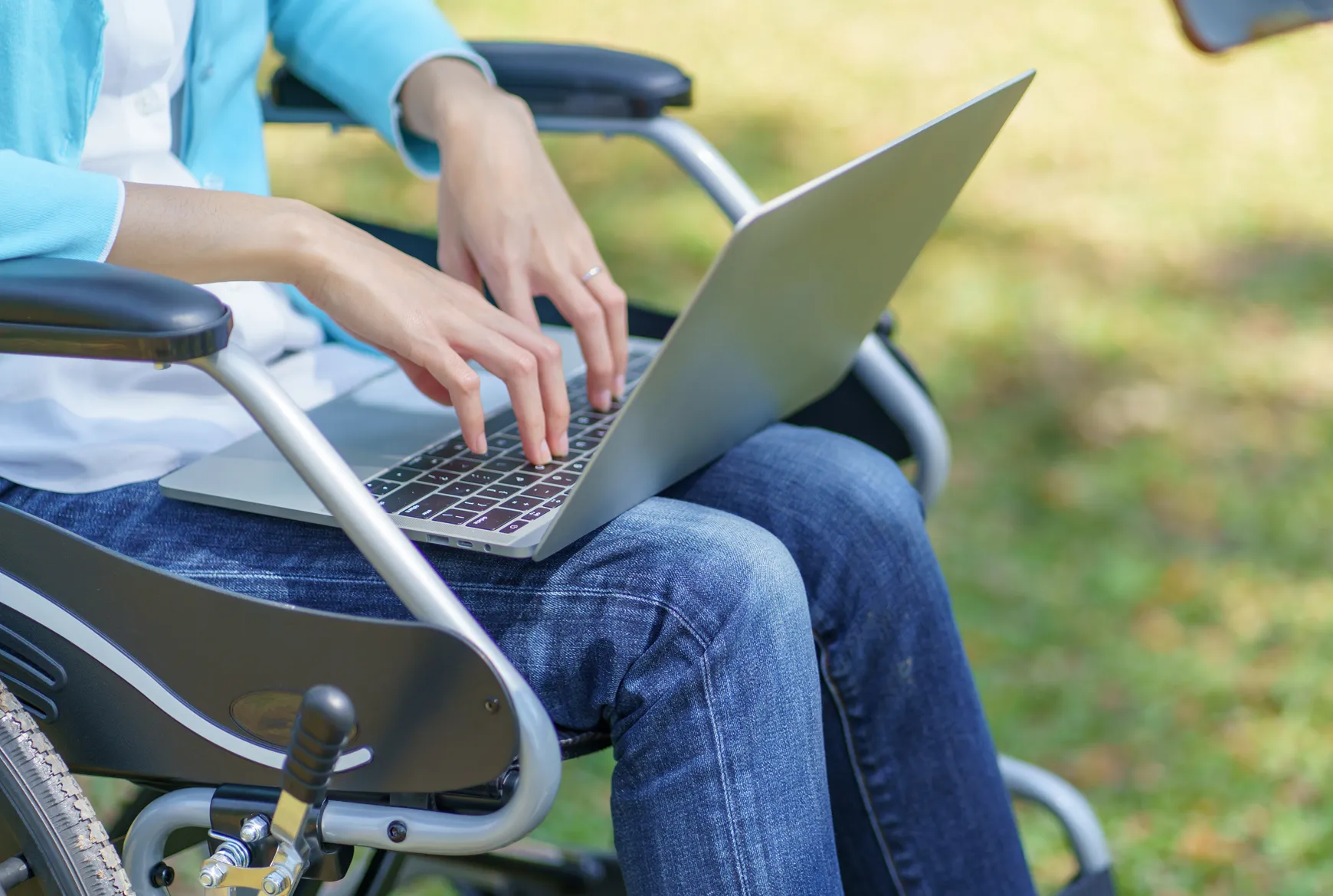 Person im Rollstuhl nutzt Laptop für digitale Pflegeberatung in Niedersachsen